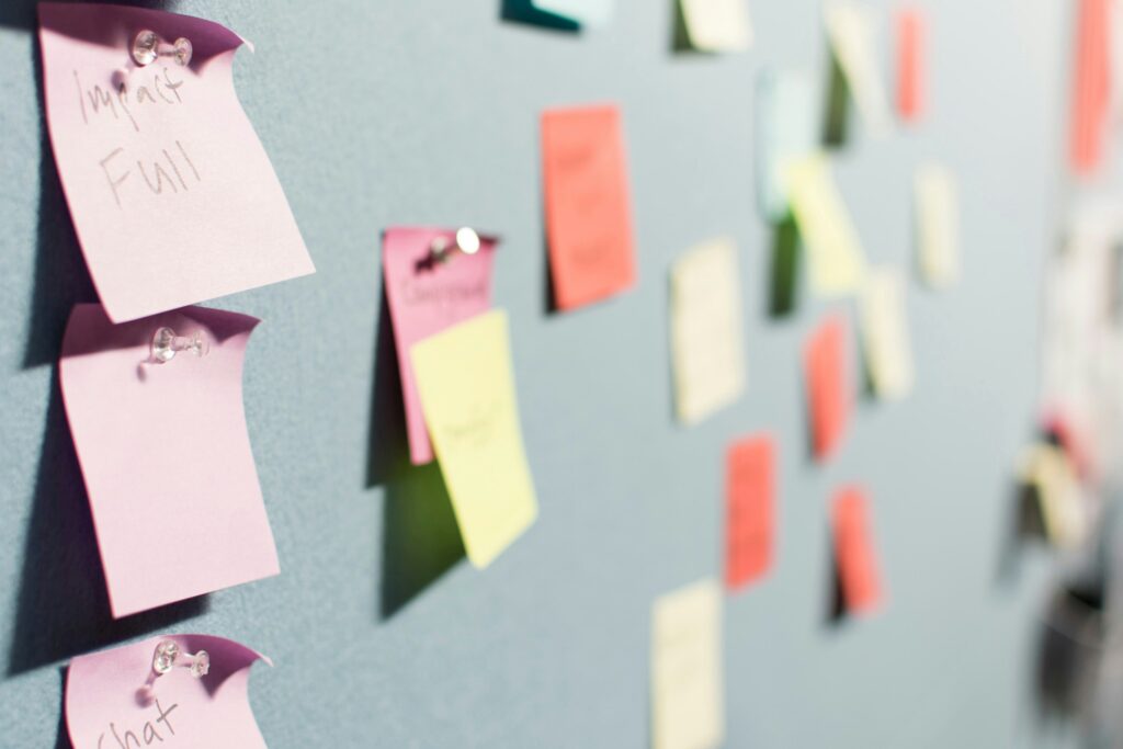 A wall covered in colourful sticky notes used during a workshop or brainstorming session